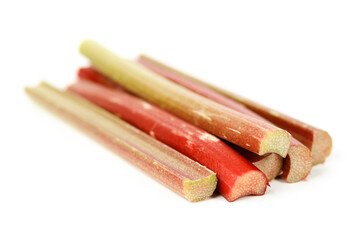 Sour rhubarb sticks on a white background, selective focus.