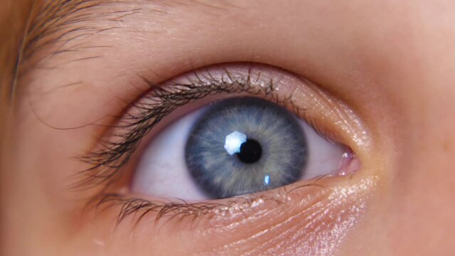 A close-up of the child's blue eye. The eyelid blinks several times. The eyeball. Human pupil. The beautiful blue eye of a girl
