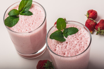 Fresh strawberry milkshake garnished with mint leaves.Cool summer drink. Selective focus.