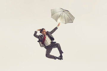 Portrait of young man dressed in 50s, 60s style with umbrella isolated on white background. Concept...