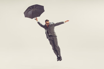 Portrait of young man dressed in 50s, 60s style with umbrella isolated on white background. Concept of culture, art, wellbeing, beauty and ad.
