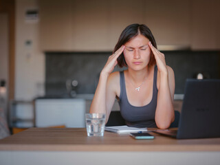 Frustrated sad woman feeling tired, worried about problem sitting at laptop, depressed girl worried about reading bad news online, debt notification email or negative message