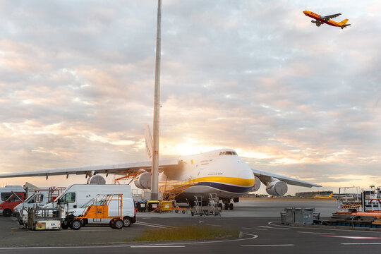 Schkeuditz, Germany - 29th May, 2022 - Laege An-124-100 ukrainian Ruslan Antonov cargo jet parked on Leipzig Halle airport terminal tarmac apron for loading and service. DHL hub sunset background