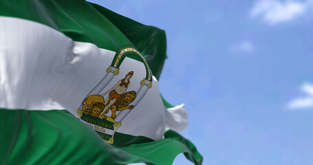 Andalusian flag waving in the wind on a clear day - obrazy, fototapety, plakaty