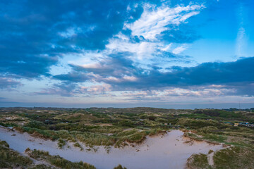 Obraz premium View of the dune landscape near Egmond aan Zee/Netherlands on a cloudy sky in the evening