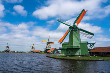 Fototapeta na wymiar View of windmills in Zaanse Schans/Netherlands under a white-blue sky