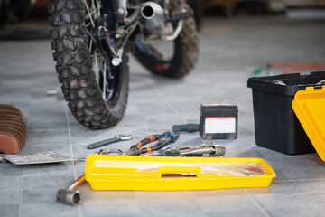 Repairing and maintenance concepts, Worktools on floor for repairing motorcycle in workshop garage