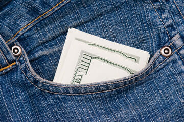Dollars in the pocket of blue denim pants close up