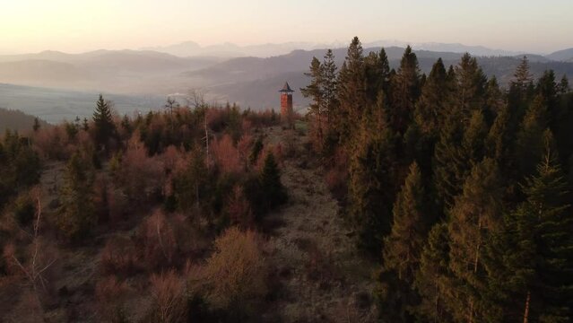 Sunrise over the Slovak countryside with a view near the town of Zborov nad Bystrica. Stone tower on the valley of Oravsk&aacute; magura. Morning orange soft light. Drone shot