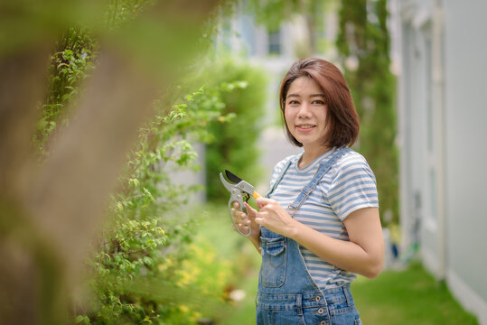 An Asian woman gardener portrait with a pruner.