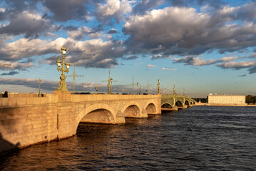 Fototapeta na wymiar Trinity Bridge in St. Petersburg at sunset. Road metal drawbridge across the Neva River in St. Petersburg. 
