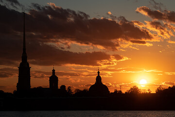 Peter and Paul Fortress dark silhouette in St. Petersburg at orange sunset.