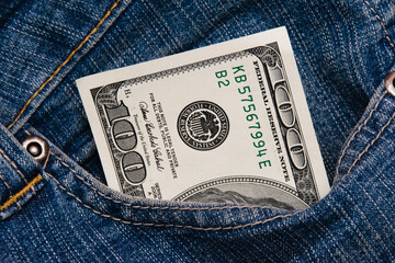 Dollars in the pocket of blue denim pants close up