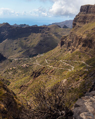 Fototapeta na wymiar Curvy roads in Masca valley leading to Masca village. Scenic mountain landscape in the Macizo de Teno mountains. Ocean in the background. Buenavista del Norte, Santa Cruz de Tenerife, Tenerife.