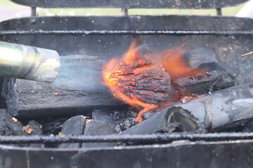 Barbecue coal lightened with a torch flame