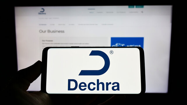 Stuttgart, Germany - 06-04-2022: Person holding cellphone with logo of British company Dechra Pharmaceuticals plc on screen in front of business webpage. Focus on phone display.