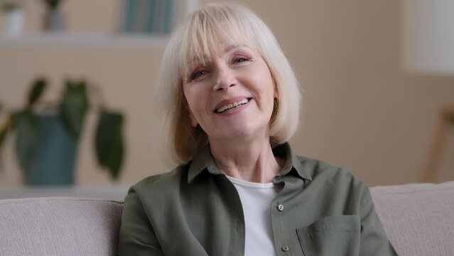 Web cam view close up happy friendly older 60s woman looking at camera talking distant remote conference calling video chat at home. Smiling senior mature adult lady grandmother speak to webcam online