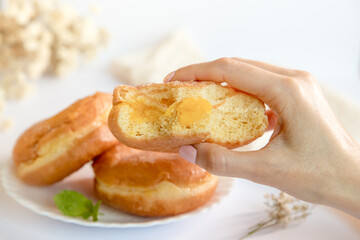 Bolas de Berlim, Berliner or donuts filled with egg jam, a very popular dessert in Portuguese pastry shops. Person tasting a berlin ball.