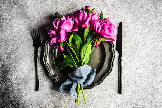 Overhead view of summer place setting with pink peonies