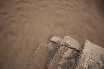 La arena devorando los elementos creados por el hombre.  - obrazy, fototapety, plakaty