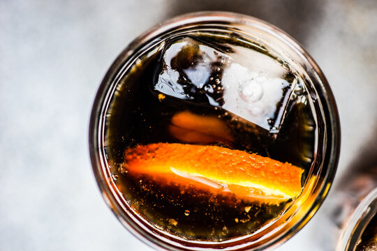 Overhead view of a cola drink with ice cubes and a slice of fresh orange