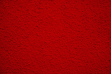 red peeling and shiny plaster on an old concrete wall