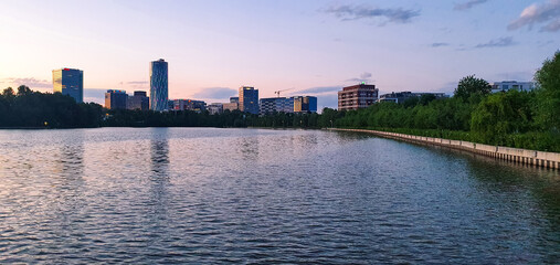 Moderne  Bürohochhäuser am Rande eines Sees in der rumänischen Hauptstadt Bukarest am Abend