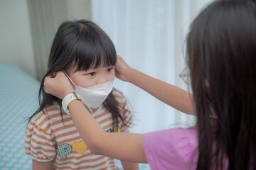 Coronavirus Covid-19 pm2.5.Online education.Little asian girl wearing face mask show thumbs up for good and happy at home. Covid-19 coronavirus.Stay home.Social distancing.New normal behavior.