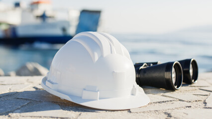 White engineer helmet and binoculars in a naval port