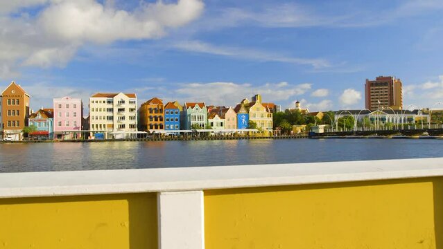 Colorful Dutch Colonial buildings along the waterfront of Saint Anna Bay in Punda, Willemstad, on the Caribbean island of Curacao. Wide angle trucking shot