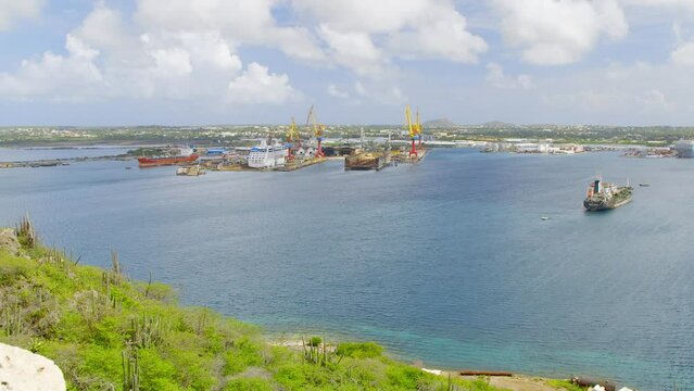 Ships docked in the busy Willemstad harbour on the Caribbean island of Curacao. High angle panning shot