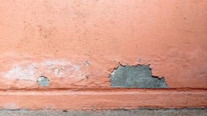 Old wall paint peeling off, making small sheets, deteriorated and decayed.