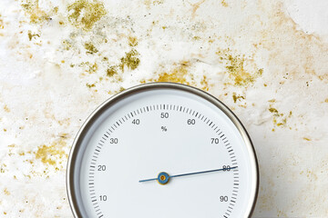 Analog hygrometer or moisture meter measuring 80 percent humidity in front of a white wall...