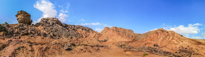 Wideangle panorama of stone mountains in the Sinai desert near Sharm El Sheikh, Egypt. Beautiful martian landscape. Bare orange-brown mountains against a blue sky