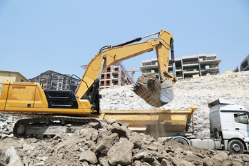 Excavator on earthworks at construction site. Backhoe on foundation work and road construction. Heavy machinery and construction equipment. Excavator under building