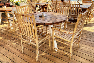 Empty wooden table and chairs in the beach cafe