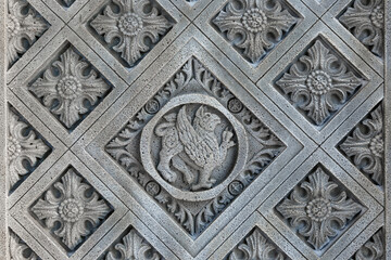 Patterns and engraving of the symbol on a stone block of a medieval castle in winter. Close-up. For the background. Gothic style