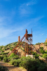 Fototapeta na wymiar Obsolete ore extraction tower in a disused and abandoned mine in Mazarrón in Murcia