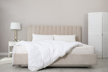Comfortable bed with soft white mattress, blanket and pillows indoors - obrazy, fototapety, plakaty