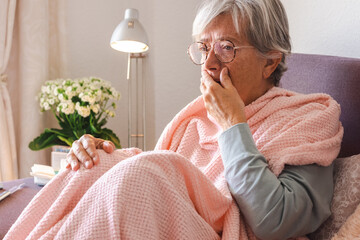 Suffering elderly adult caucasian woman with cough and fever as seasonal flu or pollen allergy...