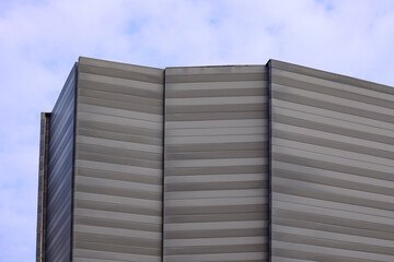 Perspective of high rise building with clouds. Business concept of future architecture. 3d rendering. Building with ACP sheets. Dynamic architecture building. Building mockup.