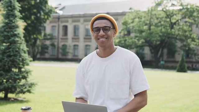 Closeup of a young African American international student sitting studying outdoor on a banch.