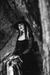 Beautiful young, gothic, sexy and witch woman from with stylized hands with black nails and...