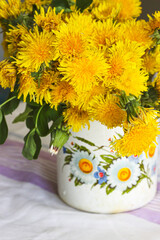 Yellow dandelions in a rustic vase - 509867056