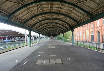 Rundbogendachen über Bahnsteig auf Bahnhofsgelände in Stadt im Frühling 
