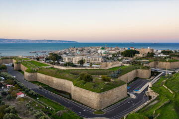 Aerial sunrise  view of Acco medieval old city with Al Jazzar mosque crusader and Ottoman city walls, arab bazaar and orange sky