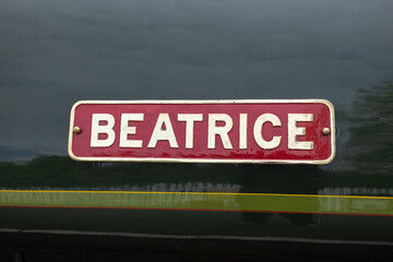 Red sign with white letters saying Beatrice on side of London North Western Railway steam train, Bolton Abbey Steam Railway, UK