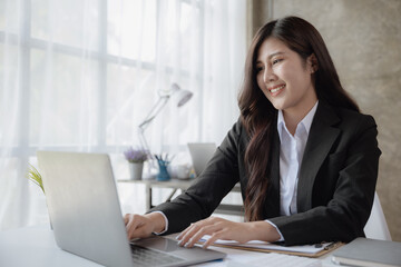 Young business women working on laptop with happy and smile face.