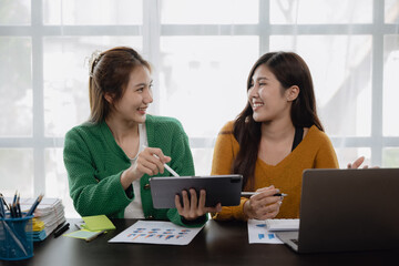 Young business women working on laptop and tablet with happy and smile face at home.