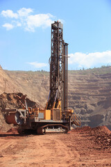 Fototapeta na wymiar Machine for drilling wells in the quarry. Drilling of boreholes for laying an explosion in a quarry. Technologies of open-pit mining of minerals.